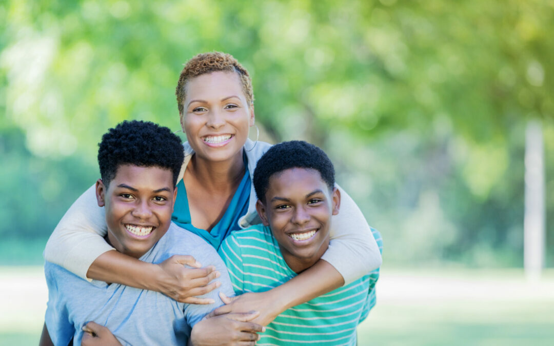 Beautiful single mom smiles for camera with two teenage sons