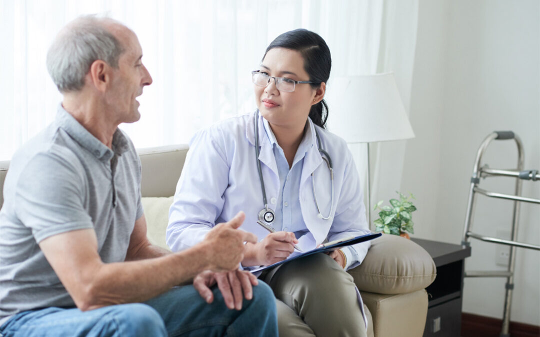 Doctor talking to senior client at home